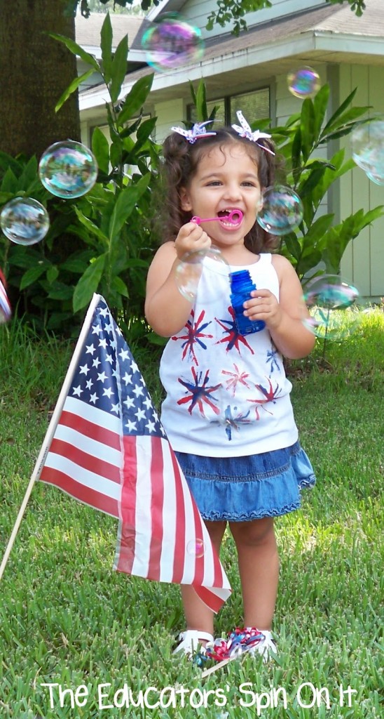 Child blowing bubbles near flag for Memorial Day