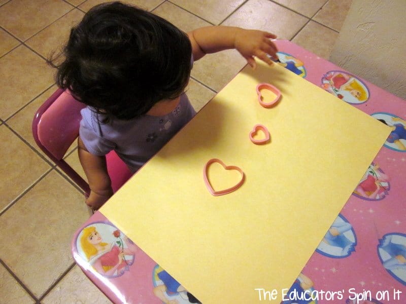 Making painting heart shapes with stamping heart cookie cutters for babies and toddlers for Valentine's Day Art Project