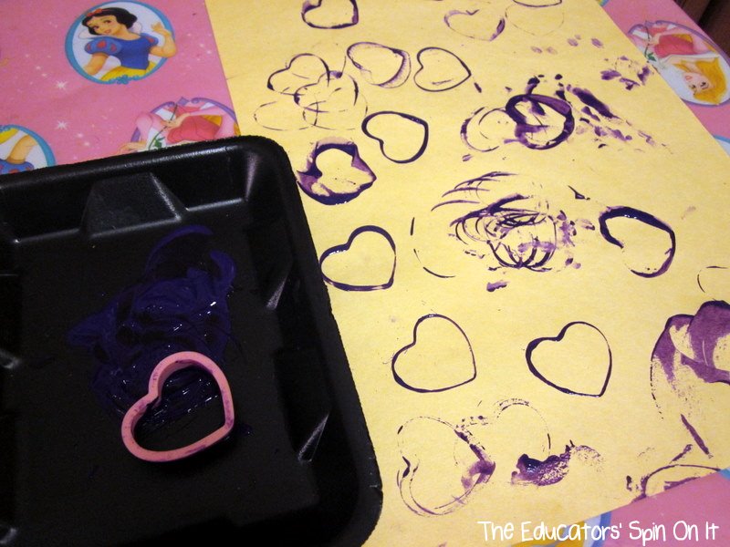 Making painting heart shapes with stamping heart cookie cutters for babies and toddlers for Valentine's Day Art
