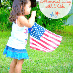 Child blowing bubbles near flag in honor of Memorial Day