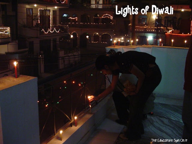 family lighting candles and diyas for diwali in India