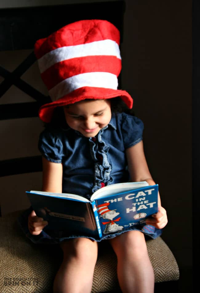 Child reading the Cat in the Hat book with red and white hat from Dr. Seuss
