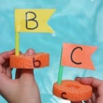 Boats made with Pool Noodles, straws and paper with letters