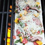 Flatbread pizza on grill with peppers, mangos, cheese and steak