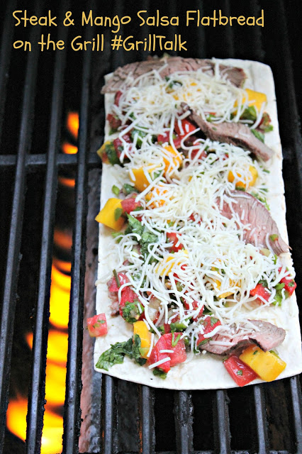 Flatbread pizza on grill with peppers, mangos, cheese and steak