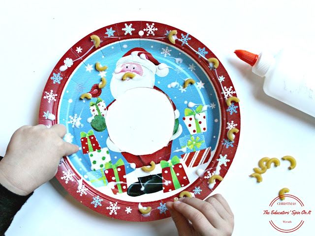 gluing noodles onto a paper plate wreath