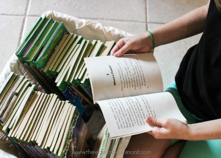 Child selecting and reading a book from the Magic Tree House Series for Kids