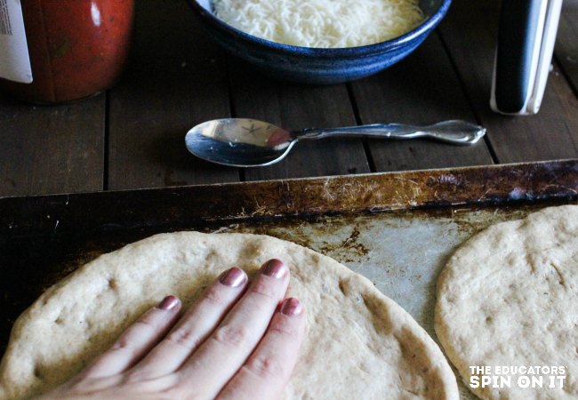 spreading dough on snowman pizza recipe