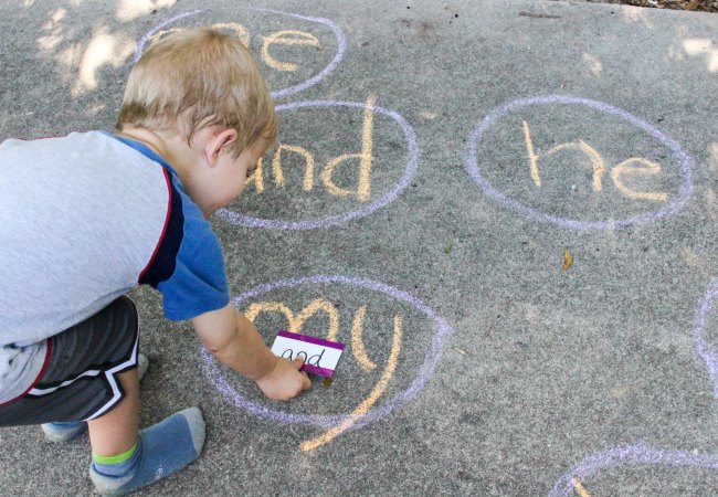 Child learning to read sight words while playing a sidewalk chalk sight word game