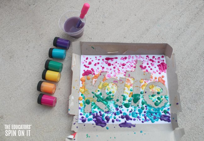 Paint dripped onto letters of name with rainbow colored jars and dropper 