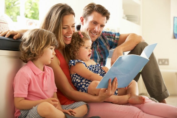 Family reading first day of school book with children