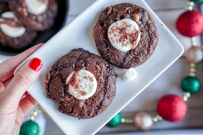 Hot chocolate cookies on white plate with red, green and gold Christmas garland in background