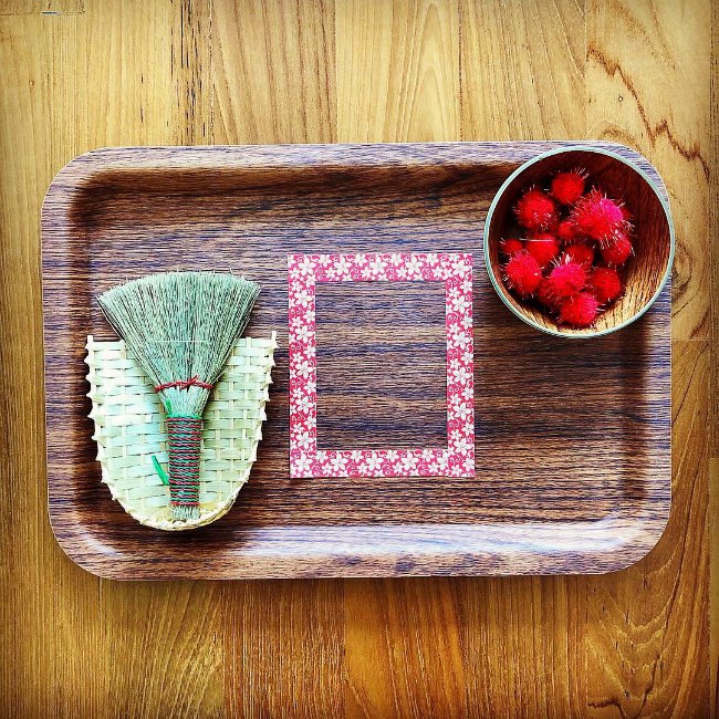 Wooden tray with small broom and red pom pom for Chinese New Year activity