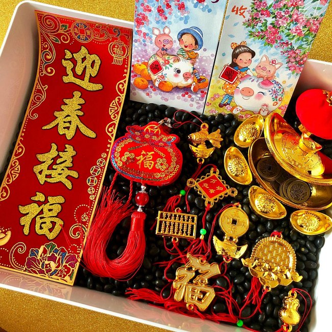 Chinese New Year Sensory Bin with Black Beans and Golden items and red envelope