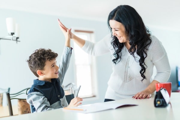 single parent support child at home at counter with school work