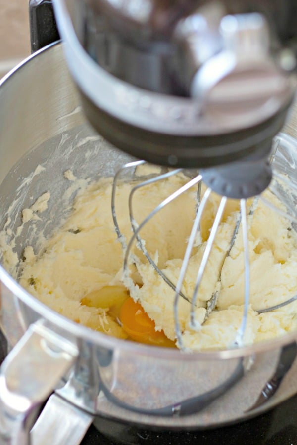 Mixing egg into cream cheese and sugar cookie batter
