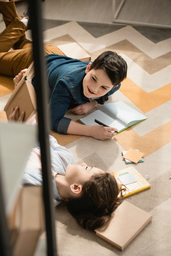 kids working on homeschooling on floor together