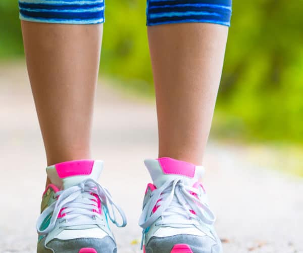 Closeup on shoe of athlete runner woman feet running on road