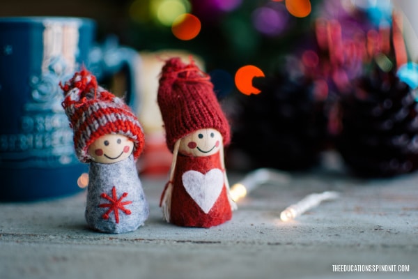 cute kindness elves on table in front of christmas tree lights sharing ideas for acts of kindness