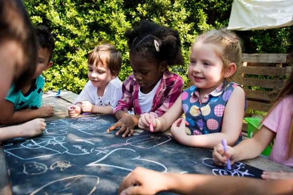 child coloring on chalkboard together at playdate for moms group