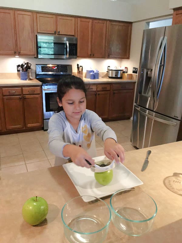 Child learning to cut apples with apple cutter for apple pie pockets