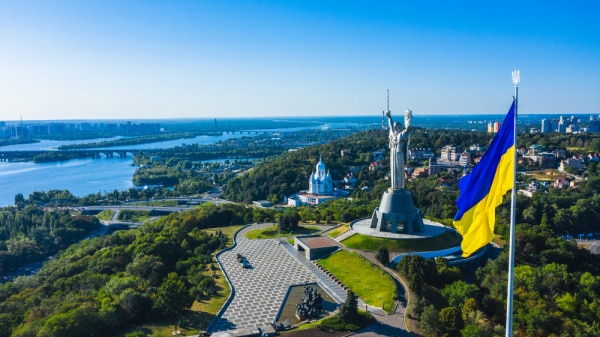 Aerial view of the beautiful landscape city Kyiv with a Dnepr river. Includes view of the Motherland statue in Kyiv. The national flag of Ukraine.