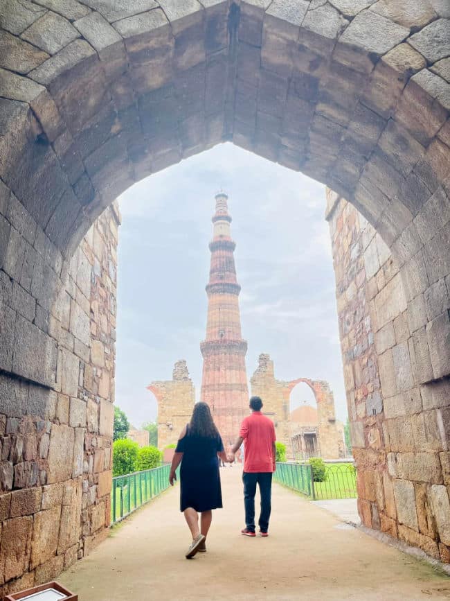 Couple looking at Qutab Minar in New Delhi, India