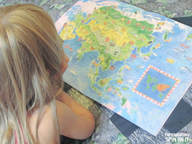 Child looking at World Atlas