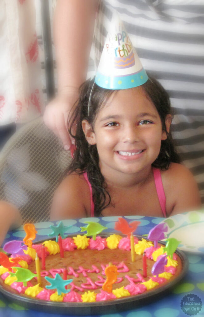 Child celebrating birthday with cookie cake