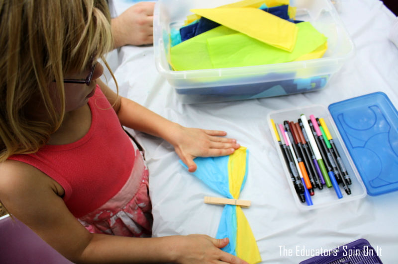 Child making tissue paper clothespin butterfly craft