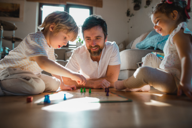 Father playing board game with kids 