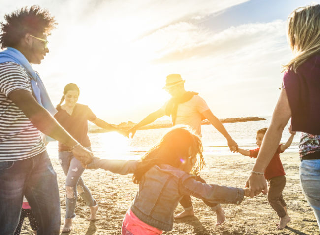 Group in circle on beach holding hands